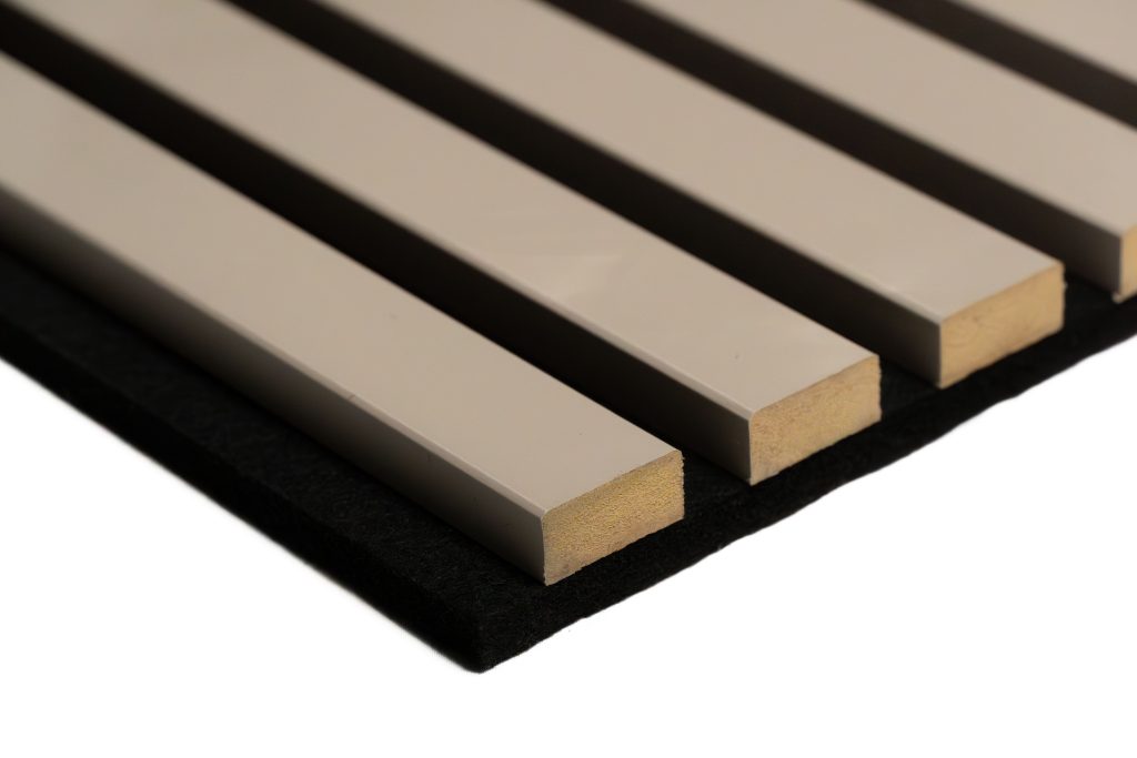 Close-up of a WoodUpp acoustic slatted panel showing four cream-coated wooden slats mounted on a black felt backing; each slat has a smooth lacquered face and exposed raw wood end grain, evenly spaced with narrow gaps to form a minimalist, sound-absorbing architectural surface.