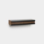 WoodUpp wall-mounted storage rail shown on a white background: a slim rectangular black metal rail with a central brown cork strip inset, rounded edges and a small shadow beneath, presenting a modern floating knife or tool rack combining metal durability with cork protection.