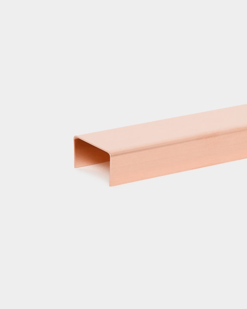 WoodUpp copper U profile cable channel displayed on a white background, a long rose-gold brushed metal U-shaped trunking and cord cover with rounded edges and open underside, photographed lengthwise to show smooth finish and squared U profile for concealing and protecting cables.