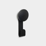 WoodUpp black wall hook with round wooden peg and integrated metal hook mounted against a white background. The minimalist piece features a matte black stained wood circular top showing grain, attached to a slim bent metal strip forming a curved lower hook for coats or bags.